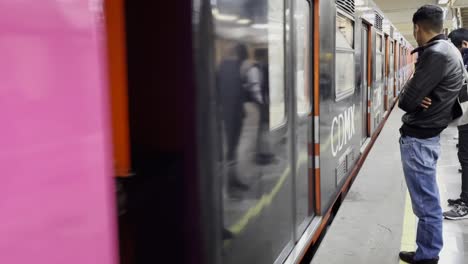 Crowded-commute-as-people-board-subway-in-a-station-in-CDMX-scene-at-the-metro-station-as-the-train-arrives-and-people-harmoniously-board