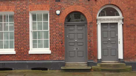 Panning-shot-of-doorsteps-of-an-old-brick-built-house-in-Manchester,-North-of-England,-UK