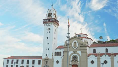 Candelaria-township-church-and-white-tower-against-blue-sky,-panning-view