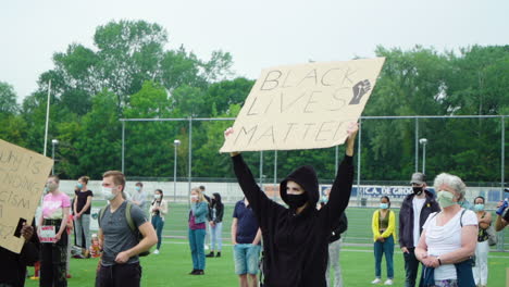 Slim-woman-dressed-in-black-holding-up-a-Black-Lives-Matter-sign-during-protest