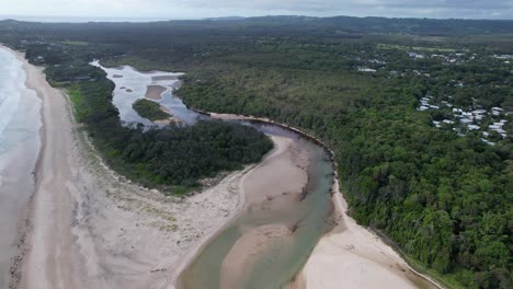 Belongil-Beach-And-Creek-Surrounded-With-Lush-Vegetation-In-Byron-Bay,-NSW,-Australia---Aerial-Drone-Shot