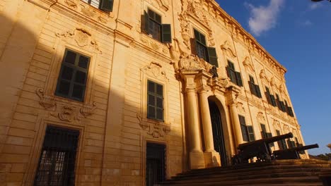 Malta,-Palacio-De-Castilla-Y-Las-Farolas-Con-Dos-Banderas,-Maltesas-Y-De-La-Unión-Europea,-Ondeando-Al-Viento