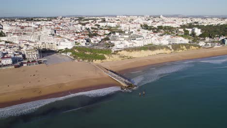 Frente-A-La-Playa-De-Albufeira-Y-Paisaje-Urbano-Encalado,-Panorámica-Aérea-Del-Algarve-Portugal