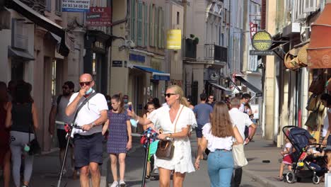 Couple-with-ice-cream-and-others-walk-by-shops-in-Antibes-Old-Town
