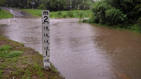Gold-Coast,-Queensland,-16-February-2024---Flooding-height-marker-across-Hardy's-Road-in-Mudgeeraba-after-heavy-rains-continue-to-lash-South-East-Queensland,-Australia