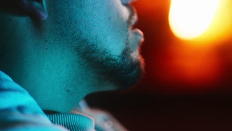 Closeup-shot-of-man-moving-its-head-with-orange-light-at-background