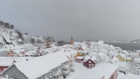 Distant-View-Of-Kragero-Church-Bell-Tower-And-Snowy-Houses-In-Winter-In-Telemark-County,-Norway