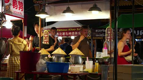 Ausländer,-Die-Auf-Dem-Lokalen-Nachtmarkt-In-Thailand-Nach-Lebensmitteln-Stöbern