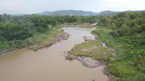 Vista-Aérea,-Agua-Turbia-Del-Río-En-Una-Zona-Forestal-En-El-País-Tropical,-Indonesia