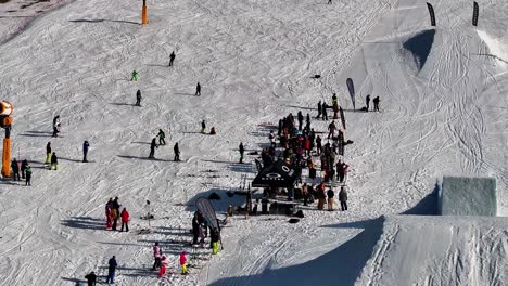 Snowy-skiing-track-with-skiers-and-people-crowd-near-ramp,-Dolni-Morava