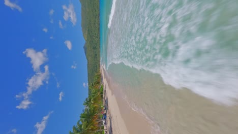 Epic-fast-low-flight-over-turquoise-Caribbean-water-and-waves-crashing-on-beach