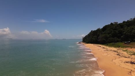 Low-aerial-drone-flight-over-an-empty-beach-in-remote-north-Queensland,-Australia