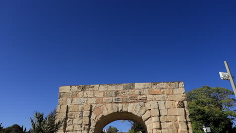 Sonniger-Tag-Mit-Den-Antiken-Römischen-Bogenruinen-In-Dougga,-Klarer-Blauer-Himmelshintergrund,-Statische-Aufnahme