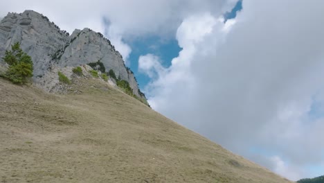 Low-angle-shot-climbing-hill-with-beautiful-clouds,-French-Alps