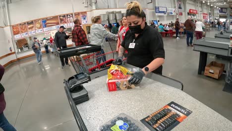 Costco-customer-pocketing-the-receipt-and-employee-putting-the-purchased-items-into-the-customer's-cart