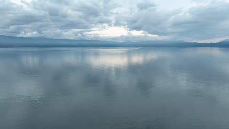 Ruhiges-Wasser-Des-Tobasees-Unter-Einem-Sanften-Himmel,-Ruhige-Und-Nachdenkliche-Stimmung,-Luftaufnahme