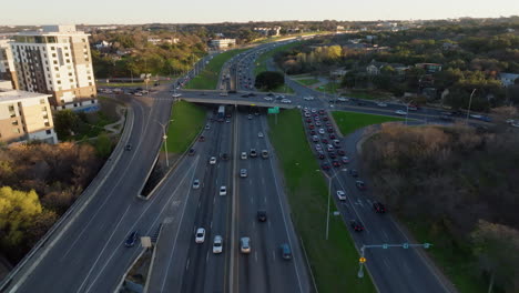 Luftaufnahme-Einer-Belebten-Stadtlandschaft:-Starker-Kreuzungsverkehr-Mit-Einer-Mischung-Aus-Autos-Und-Lastwagen-Auf-Einer-Mehrspurigen-Autobahn