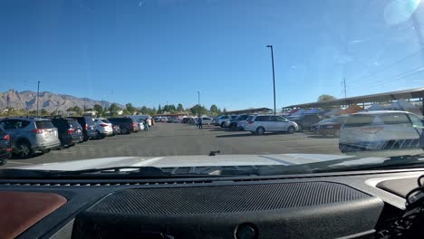 POV---Driving-thru-the-busy-parking-lot-for-a-farmer's-market-located-in-the-parking-lot-for-a-horse-race-track