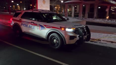 Police-Cars-Driving-Through-Yellow-Barricade-Tape-At-Night,-Leaving-Murder-Crime-Scene-In-Vaughan,-Ontario,-Canada