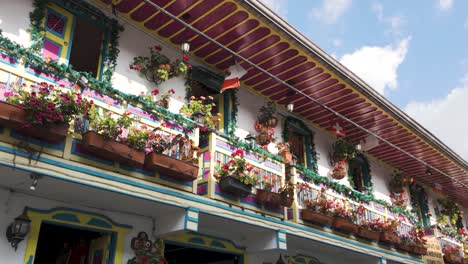 Colorful-balcony-with-flowers-and-country-flags-at-a-hostel-in-Salento,-Colombia