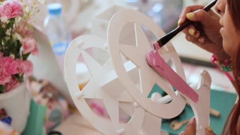 Fortune-wheel-starting-to-be-painted-pink,-in-the-craft-workshop