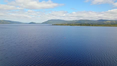 Aerial-view-dolly-in-of-two-people-kayaking-on-huillinco-lake-in-Chiloe,-Chile