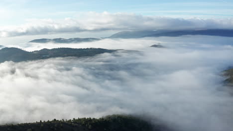 Misty-mountains-with-treetops-emerging-from-the-sea-of-clouds,-serene-nature-scene