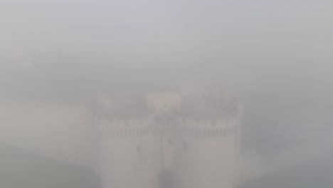 An-aerial-perspective-amidst-foggy-conditions-captures-the-majestic-presence-of-Tour-Philippe-le-Bel-,-an-ancient-medieval-tower-located-in-Villeneuve-lès-Avignon,-France