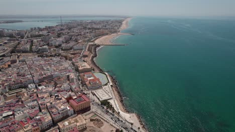 Imágenes-De-Aproximación-Aérea-De-La-Ciudad-De-Cádiz-Con-Vistas-A-La-Zona-Costera-Y-Al-Casco-Antiguo,-Cádiz-España