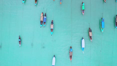 Long-Tail-boats-with-Top-Down-View-Over-Turquoise-Waters-Along-the-Beach-and-Wooden-Huts-in-Thailand