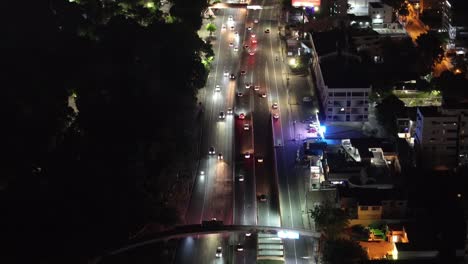 Vista-Aérea-Del-Tráfico-Nocturno-De-La-Avenida-En-El-Barrio-Residencial-De-Santo-Domingo,-República-Dominicana,-Revelando-El-Paisaje-Urbano