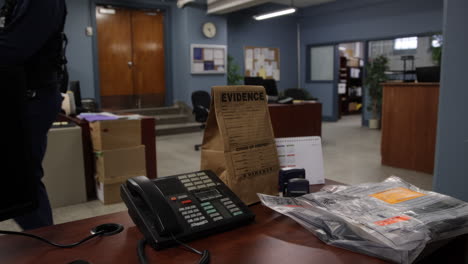 Police-officer-walking-past-table-of-evidence