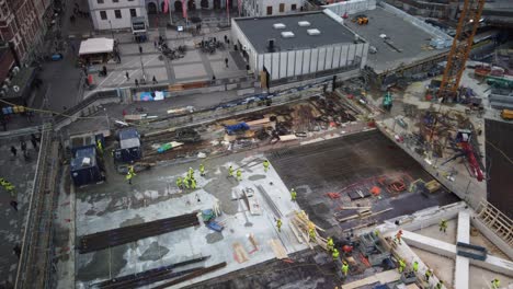 Workers-move-around-at-construction-site-at-Slussen-in-Stockholm,-from-above