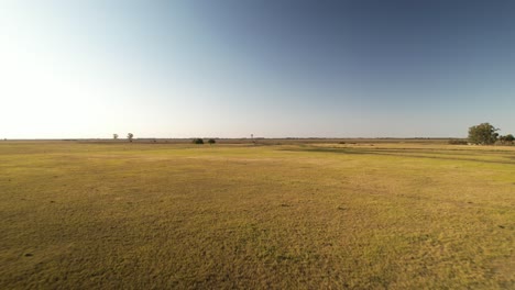 Panorama-Vorbeiflug-über-Eine-Trockene-Ebene-Nähert-Sich-Einer-Windmühle,-Buenos-Aires,-Argentinien