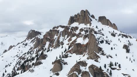 Schneebedeckte-Ciucas-Berge-Unter-Bewölktem-Himmel,-Felsige-Gipfel,-Winterlandschaft,-Luftaufnahme
