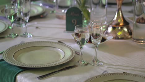 Mesa-De-Madera-Decorada-Para-Un-Banquete,-Con-Cubiertos,-Platos-De-Cerámica-Y-Vasos-De-Cristal.