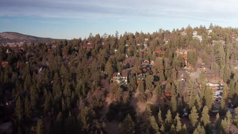 Toma-Aérea-De-Una-Hermosa-Cabaña-De-Montaña-Con-Vista-Al-Bosque-Alpino-De-Big-Bear-Lake,-California.