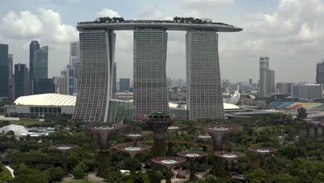 Marina-Bay-Sands-Hotel-Aerial-Drone-Push-in-Shot-Over-Gardens-by-the-Bay-in-Singapore