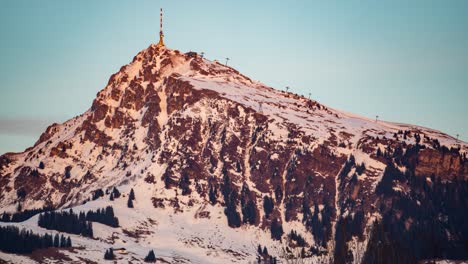 Telecommunication-tower-on-top-of-rocky-snowy-mountain,-time-lapse-view