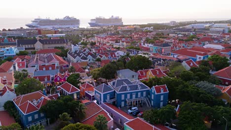 Atemberaubende-Historische-Bunte-Gebäude-Des-Dorfes-Kura-Hulanda-In-Otrobanda,-Willemstad,-Curaçao,-Mit-In-Der-Ferne-Angedockten-Kreuzfahrtschiffen