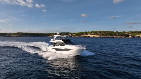 Drone-shot-of-luxury-yacht-driving-next-to-coastline