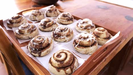 Freshly-baked-cinnamon-buns-being-glazed-with-sugar