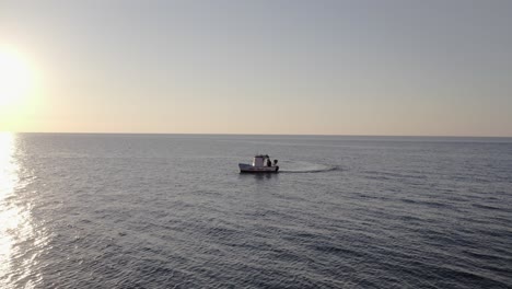 Aerial-view-of-fishing-boat-on-Mediterranean-Sea-at-sunset,-Sicily,-Italy