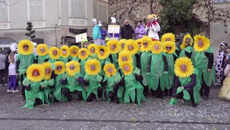 A-group-of-adults-dressed-up-as-sunflowers-pose-for-cameras-during-the-annual-carnival-celebration-called-Gnoccolada-in-Brixen---Bressanone,-South-Tyrol,-Italy