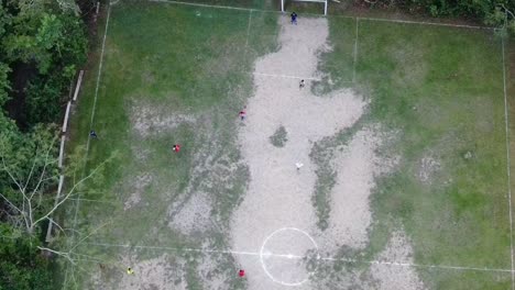Drone-aerial-view-in-Peru-top-view-in-the-amazon-rainforest-showing-kids-playing-football-on-a-grass-court