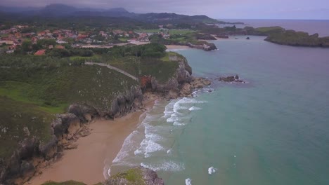 Luftaufnahme-Eines-Abgeschiedenen-Strandes-Und-Der-Klippen-In-Der-Nähe-Des-Dorfes