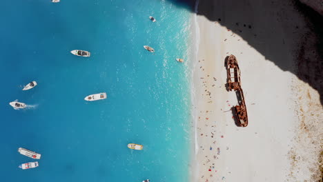 Aéreo:-Vista-De-Arriba-Hacia-Abajo-De-La-Playa-De-Navagio-Con-El-Famoso-Barco-Hundido-Y-Aguas-Turquesas-En-Zante,-Grecia