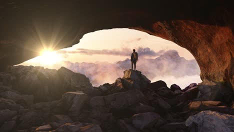 Un-Excursionista-Aventurero-Parado-En-Una-Cueva-Con-Espectaculares-Nubes-Y-Vistas-A-Las-Montañas-Nevadas