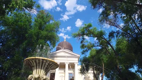 Fountain-in-front-of-the-Spaso-Preobrazhensky-Cathedral,-bright-blue-sky-with-the-clouds-over-the-dome,-Odessa-Ukraine