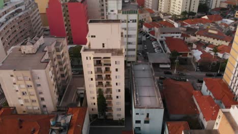 Experimente-Una-Revelación-Urbana-Cuando-La-Inclinación-De-Un-Dron-Revela-Un-Bullicioso-Paisaje-Urbano,-Capturando-La-Esencia-De-La-Vida-De-La-Ciudad-En-Un-Día-Normal.